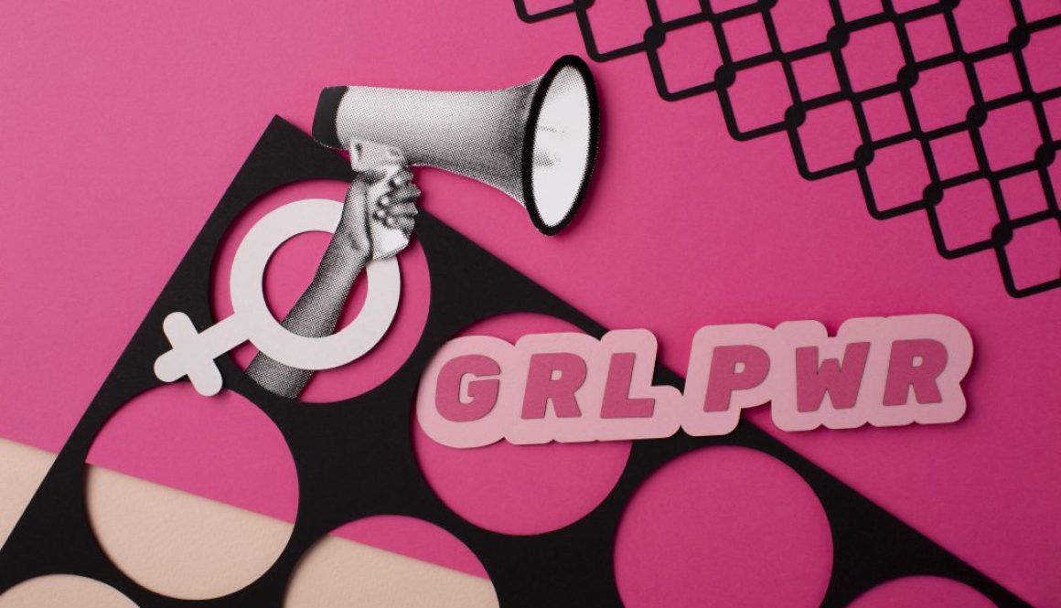 A creative and bold flat lay artwork featuring feminist symbols on a pink background. A hand holding a megaphone emerges from a female gender symbol cutout, and the phrase “GRL PWR” (Girl Power) is displayed in large pink letters. The design includes a mix of black and pink geometric patterns, emphasizing empowerment and modern feminism.